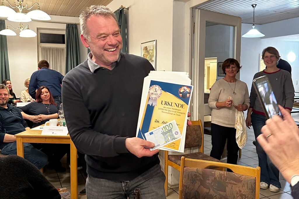 Sven Forker zeigt stolz die Urkunde für den errungenen Platz drei beim 1. Nürnberger LIONS Pub Quiz